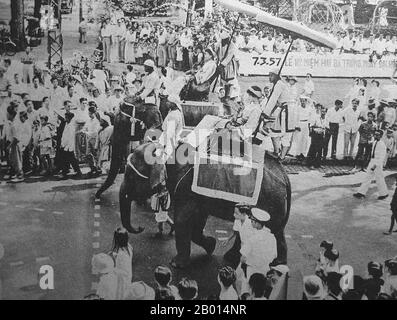 Vietnam: La Parata delle Suore Trung (Hai Ba Trung) a Saigon, 26 aprile 1957. Due donne vietnamite sul dorso dell'elefante rappresentano le celebrate Suore Trung (Hai Ba Trung) nella sfilata annuale Hai Ba Trung, Saigon, 26 aprile 1957. Le Suore Trưng (c.. 12 - 43 CE), conosciuta in vietnamita come Hai Bà Trưng (letteralmente 'le due Trưng Signore'), e individualmente come Trưng Trắc e Trưng Nhị, furono due leader di donne vietnamite del primo secolo che si ribellarono con successo contro il dominio cinese della dinastia Han per tre anni, e sono considerate eroine nazionali del Vietnam. Foto Stock