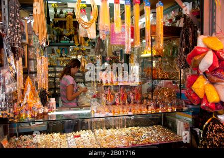 Thailandia: Negozio di articoli religiosi, amuleto e paraphernalia mercato religioso a Wat Ratchanatda, Bangkok. Il mercato della paraphernalia religiosa all'interno dei terreni di Wat Ratchanatda vende immagini di Buddha e fascino buddista in tutte le forme e dimensioni, nonché una varietà di divinità indù indiane e articoli religiosi cinesi. Wat Ratchanadfaram fu costruito su ordine del re Nangklao (Rama III) per la mamma Chao Ying Sommanus Wattanavadi nel 1846. Il tempio è meglio conosciuto per la Loha Prasada (Loha Prasat), una struttura a più livelli alta 36 m e con 37 guglie metalliche. Foto Stock