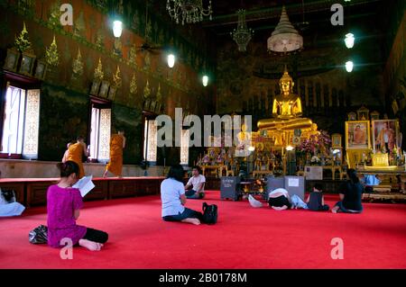 Thailandia: Devoti nel viharn principale, Wat Rakhang, Bangkok. Wat Rakhang Kositaram Woramahawihan (Rakang) è stato originariamente costruito durante il periodo Ayutthaya (1351 - 1767), ma è stato ristrutturato dal re Buddha Yodfa Chulaloke (Rama i, 20 marzo 1736 – 7 settembre 1809), e si trova sul lato Thonburi del fiume Chao Phraya di Bangkok. Rama ho vissuto all'interno del tempio prima che diventasse re. Foto Stock