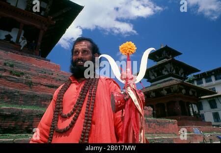 Nepal: Sadhu (uomo Santo) in Piazza Durbar, Kathmandu. Sono conosciuti, variamente, come sadhus (santi, o 'buoni '), yoga (praticanti ascetici), Fakirs (cercatore ascetico dopo la verità) e sannyasins (mendicanti e ascetici vaganti). Sono i praticanti ascetici – e spesso eccentrici – di una forma austera di induismo. Giurati di cacciare i desideri terreni, alcuni scelgono di vivere come ancoriti nel deserto. Altri sono meno ritirati, soprattutto nelle città e nei templi della valle di Kathmandu in Nepal. Foto Stock