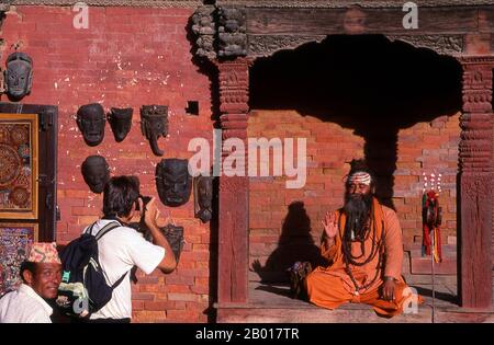 Nepal: Sadhu (uomo Santo) in Piazza Durbar, Kathmandu. Sono conosciuti, variamente, come sadhus (santi, o 'buoni '), yoga (praticanti ascetici), Fakirs (cercatore ascetico dopo la verità) e sannyasins (mendicanti e ascetici vaganti). Sono i praticanti ascetici – e spesso eccentrici – di una forma austera di induismo. Giurati di cacciare i desideri terreni, alcuni scelgono di vivere come ancoriti nel deserto. Altri sono meno ritirati, soprattutto nelle città e nei templi della valle di Kathmandu in Nepal. Foto Stock