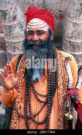 Nepal: Sadhu (uomo Santo) in Piazza Durbar, Kathmandu. Sono conosciuti, variamente, come sadhus (santi, o 'buoni '), yoga (praticanti ascetici), Fakirs (cercatore ascetico dopo la verità) e sannyasins (mendicanti e ascetici vaganti). Sono i praticanti ascetici – e spesso eccentrici – di una forma austera di induismo. Giurati di cacciare i desideri terreni, alcuni scelgono di vivere come ancoriti nel deserto. Altri sono meno ritirati, soprattutto nelle città e nei templi della valle di Kathmandu in Nepal. Foto Stock