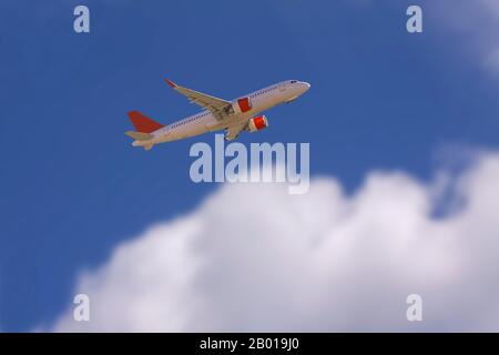 Un aereo aereo aereo nel cielo blu che vola sopra grandi nuvole bianche sfocate. Immagine con spazio di copia. Foto Stock