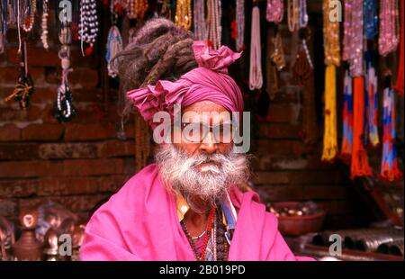 Nepal: Sadhu, Pashupatinath, Kathmandu. Sono conosciuti, variamente, come sadhus (santi, o 'buoni '), yoga (praticanti ascetici), Fakirs (cercatore ascetico dopo la verità) e sannyasins (mendicanti e ascetici vaganti). Sono i praticanti ascetici – e spesso eccentrici – di una forma austera di induismo. Giurati di cacciare i desideri terreni, alcuni scelgono di vivere come ancoriti nel deserto. Altri sono meno ritirati, soprattutto nelle città e nei templi della valle di Kathmandu in Nepal. Foto Stock