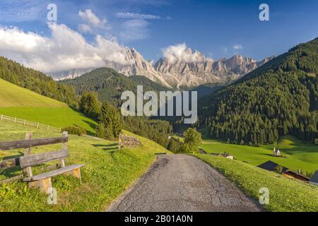 Splendida vista sul villaggio di S. Maddalena, Val di Funes (Villnob) con montagne del Gruppo Odle sullo sfondo, Alpi Dolomiti, Bolzano, Alto Adige, Italia. Foto Stock