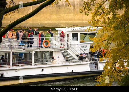 Parigi, Francia - 11 novembre 2019: Un tour in barca, con i turisti, lungo la Senna, mentre passa attraverso il ponte Tournelle Foto Stock