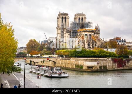 Parigi, Francia - 11 novembre 2019: Cattedrale di Notre Dame con impalcature di riparazione e un giro in barca dopo aver attraversato sotto il ponte dell'arcivescovo, da t. Foto Stock