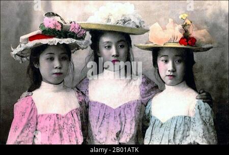 Giappone: Tre giovani donne vestite in stile occidentale. Fotografia colorata a mano di Enami Nobukuni (1859-1929), c.. 1895. T. Enami era il nome commerciale di un celebre fotografo del periodo Meiji. Il T. del suo nome commerciale è pensato per essere stato per Toshi, anche se non ha mai scritto fuori su qualsiasi documento personale o di affari. Nato a Edo (ora Tokyo) durante l'era Bakumatsu, Enami fu prima studente di, e poi assistente del noto fotografo e collotipista, Ogawa Kazumasa. Enami si è rilocato a Yokohama, e ha aperto uno studio a Benten-dōri (Benten Street) nel 1892. Foto Stock