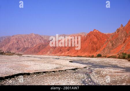 Cina: Le montagne rosse del Ghez (Ghez Darya) canyon, Karakoram Highway. La Zhongba Gonglu o Karakoram Highway è una meraviglia ingegneristica che è stata aperta nel 1986 e rimane la strada asfaltata più alta del mondo. Collega la Cina e il Pakistan attraverso la catena montuosa del Karakoram, attraverso il Passo Khunjerab, ad un'altitudine di 4.693 m/15.397 ft. Foto Stock