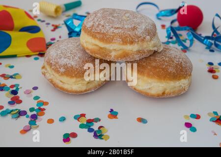 Primo piano di tre ciambelle con decorazione carnevale intorno a loro Foto Stock