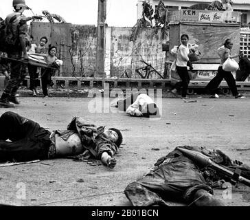 Vietnam: Con paura e apprensione che mostrano sul loro volto donne e bambini carichi di beni recuperati scurry oltre i corpi di tre NLF (Viet Cong) uccisi nel combattimento, Saigon, maggio 1968. La seconda guerra indochina, conosciuta in America come la guerra del Vietnam, fu un conflitto militare dell'epoca della guerra fredda che si verificò in Vietnam, Laos e Cambogia dal 1 novembre 1955 alla caduta di Saigon il 30 aprile 1975. Questa guerra seguì la prima Guerra d'Indocina e fu combattuta tra il Vietnam del Nord, sostenuto dai suoi alleati comunisti, e il governo del Vietnam del Sud, sostenuto dagli Stati Uniti Foto Stock