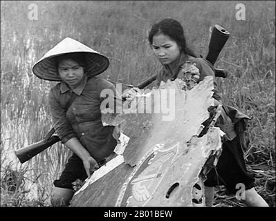 Vietnam: Due combattenti nazionali di liberazione (NLF, Viet Cong) donne caccia salvare i relitti da un aereo USAF abbattuto, c.. 1968. La seconda guerra d'Indocina, conosciuta in America come guerra del Vietnam, fu un conflitto militare dell'epoca della guerra fredda che si verificò in Vietnam, Laos e Cambogia dal 1 novembre 1955 alla caduta di Saigon il 30 aprile 1975. Questa guerra seguì la prima Guerra d'Indocina e fu combattuta tra il Vietnam del Nord, sostenuto dai suoi alleati comunisti, e il governo del Vietnam del Sud, sostenuto dagli Stati Uniti e da altre nazioni anticomuniste. Foto Stock