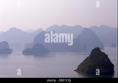 Vietnam: Tramonto bagliore, vista da Dao Titop, Baia di ha Long, Provincia di Quang Ninh. In vietnamita ha long significa “drago discendente”, e la leggenda narra che Halong Bay sia stata formata da un gigantesco drago che si è immerso nel Golfo di Tonkin, creando migliaia di affioramenti calcarei con il taglio della coda. I geologi tendono a ignorare questa teoria, sostenendo che la miriade di isole che punteggiano Halong Bay e si estendono fino alla frontiera cinese sono il prodotto dell'erosione selettiva dei fondali marini nel corso dei millenni. Foto Stock