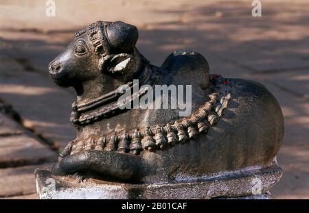 India: Nandi il toro (monte di Shiva), tempio Virupaksha, Hampi, stato di Karnataka. Nandi (Nandin) il toro era il mitico monte del dio Shiva nella mitologia indù. Il Tempio di Virupaksha (conosciuto anche come Tempio di Pampapathi) è il principale centro di pellegrinaggio di Hampi. E' completamente intatto tra le rovine circostanti ed è ancora utilizzato nel culto. Il tempio è dedicato al Signore Shiva, qui conosciuto come Virupaksha, come la consorte della dea locale Pampa, associata al fiume Tungabhadra. Hampi è un villaggio nel nord dello stato di Karnataka. Si trova all'interno delle rovine di Vijayanagara. Foto Stock