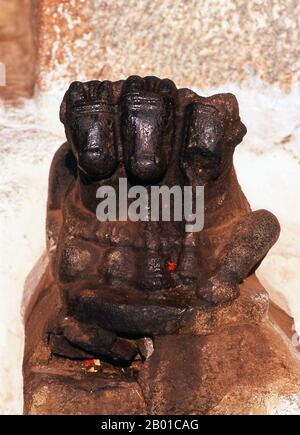 India: Nandi il toro (monte di Shiva), tempio Virupaksha, Hampi, stato di Karnataka. Nandi (Nandin) il toro era il mitico monte del dio Shiva nella mitologia indù. Il Tempio di Virupaksha (conosciuto anche come Tempio di Pampapathi) è il principale centro di pellegrinaggio di Hampi. E' completamente intatto tra le rovine circostanti ed è ancora utilizzato nel culto. Il tempio è dedicato al Signore Shiva, qui conosciuto come Virupaksha, come la consorte della dea locale Pampa, associata al fiume Tungabhadra. Hampi è un villaggio nel nord dello stato di Karnataka. Si trova all'interno delle rovine di Vijayanagara. Foto Stock