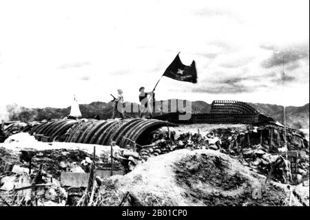 Vietnam: Le truppe vittoriose di Viet Minh hanno fatto sventolare una bandiera vietnamita che ha conquistato posizioni francesi a Dien Bien Phu, 1954. L'importante battaglia di Dien Bien Phu fu combattuta tra il Việt Minh (guidato dal generale Vo Nguyen Giap) e l'Unione francese (guidata dal generale Henri Navarre, successore del generale Raoul Salan). L'assedio della guarnigione francese durò cinquantasette giorni, dalle 5:30PM del 13 marzo alle 5:30PM del 7 maggio 1954. L'avamposto meridionale o la base del fuoco del campo, Isabelle, non seguì l'ordine del cessate il fuoco e combatté fino al giorno successivo alle 01:00:00. Foto Stock