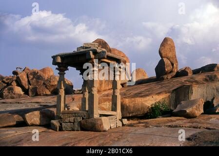 India: Prime rovine del tempio di Jain sulla collina di Hemakuta che domina il tempio di Virupaksha e il bazar, Hampi, stato di Karnataka. Hampi è un villaggio nel nord dello stato di Karnataka. Si trova all'interno delle rovine di Vijayanagara, l'ex capitale dell'Impero Vijayanagara. Prima della città di Vijayanagara, continua ad essere un importante centro religioso, che ospita il Tempio di Virupaksha, nonché diversi altri monumenti appartenenti alla città vecchia. Il Jainism è una religione indiana che prescrive il pacifism ed un percorso di non-violenza verso tutti gli esseri viventi. Foto Stock