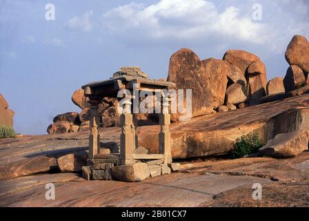 India: Prime rovine del tempio di Jain sulla collina di Hemakuta che domina il tempio di Virupaksha e il bazar, Hampi, stato di Karnataka. Hampi è un villaggio nel nord dello stato di Karnataka. Si trova all'interno delle rovine di Vijayanagara, l'ex capitale dell'Impero Vijayanagara. Prima della città di Vijayanagara, continua ad essere un importante centro religioso, che ospita il Tempio di Virupaksha, nonché diversi altri monumenti appartenenti alla città vecchia. Il Jainism è una religione indiana che prescrive il pacifism ed un percorso di non-violenza verso tutti gli esseri viventi. Foto Stock