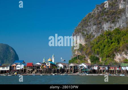 Thailandia: Villaggio di pescatori musulmani di Panyi, Parco Nazionale di Ao Phang Nga (Baia di Phangnga), Provincia di Phang Nga. Ko Panyi è un enorme affioramento carsico nel lee di cui un prospero villaggio di pescatori musulmano tailandese si rifugia dal Monsone Sud-Ovest. L'insolita ubicazione del villaggio di pescatori musulmano palafittato, insieme alla moschea e al minareto inaspettati, ha fornito agli abitanti di Ko Panyi una fonte di reddito supplementare inaspettata e gradita negli anni dall'avvento del turismo. Anche se l'isola è diventata commercializzata, la gente è notevolmente aperta e amichevole. Foto Stock