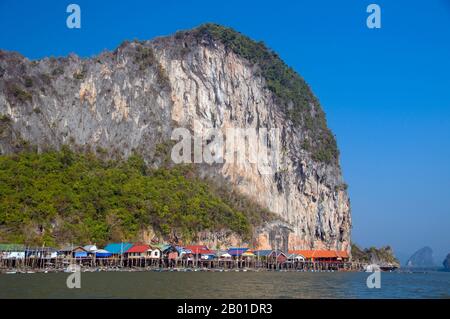 Thailandia: Villaggio di pescatori musulmani di Panyi, Parco Nazionale di Ao Phang Nga (Baia di Phangnga), Provincia di Phang Nga. Ko Panyi è un enorme affioramento carsico nel lee di cui un prospero villaggio di pescatori musulmano tailandese si rifugia dal Monsone Sud-Ovest. L'insolita ubicazione del villaggio di pescatori musulmano palafittato, insieme alla moschea e al minareto inaspettati, ha fornito agli abitanti di Ko Panyi una fonte di reddito supplementare inaspettata e gradita negli anni dall'avvento del turismo. Anche se l'isola è diventata commercializzata, la gente è notevolmente aperta e amichevole. Foto Stock