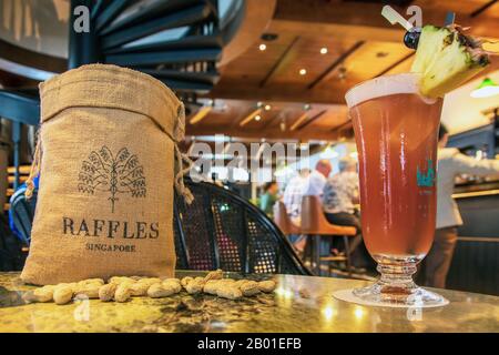 All'interno del famoso Raffles Long Bar, Singapore, che mostra una tradizionale borsa di arachidi con il nome Raffles, accanto ad un famoso cocktail di gin, un Sin Foto Stock