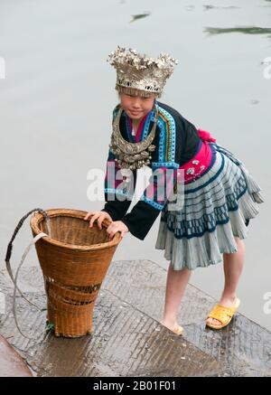 Cina: Ragazza Han vestita in costume tradizionale Miao, Fenghuang, Provincia di Hunan. Fenghuang è cinese per Phoenix e si riferisce al mitico uccello da fuoco sacro che si può trovare nelle mitologie dei Persiani, Greci, Romani, Egiziani, Cinesi, E (secondo Sanchuniathon) i Fenici. La leggenda suggerisce che due phoenixes sulla scoperta della città hovered sopra per un certo tempo considerevole prima di volare riluttante via. Fenghuang è un'antica città ben conservata che risale al 248 a.C. Ospita le minoranze Miao e Tujia. Foto Stock