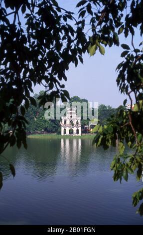 Vietnam: Thap Rua (Torre della Tartaruga) ho Hoan Kiem, Hanoi. Ho Hoan Kiem significa “Lago della spada restaurata”, un corpo d’acqua che si trova nel cuore di Hanoi. Fino al 15th ° secolo fu chiamato Luc Thuy o 'acqua verde'. La leggenda vuole che durante l'occupazione di Ming (1407-28), il generale le Loi fu presentato con una spada magica da una tartaruga divina che viveva nelle acque. Con l'aiuto di questa spada, le Loi espulse i cinesi dal nord del Vietnam e si stabilì come imperatore le Thai a. Più tardi, quando l'imperatore navigava sul lago, la tartaruga si alzò in superficie e ripresero la spada Foto Stock