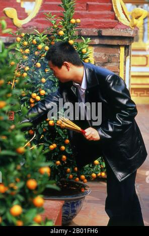 Vietnam: Tet (Capodanno vietnamita) celebranti a Tran Quoc Pagoda, ho Tay (Lago Ovest), Hanoi. Il tempio più antico di Hanoi, Chua Tran Quoc, si trova su una piccola isola appena ad ovest della strada sopraelevata di ho Tay. Le origini precise della pagoda sono sconosciute, ma secondo la leggenda fu originariamente fondata dalle rive del Fiume Rosso durante il regno di Re Ly Nam De (544-548) in un breve interregno durante il millennio dell’occupazione cinese. La più grande festa nazionale del Vietnam è Tet – più propriamente, Tet Nguyen Dan, “Festival del primo giorno” – in coincidenza con il primo giorno del capodanno lunare. Foto Stock