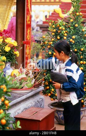 Vietnam: Tet (Capodanno vietnamita) celebranti a Tran Quoc Pagoda, ho Tay (Lago Ovest), Hanoi. Il tempio più antico di Hanoi, Chua Tran Quoc, si trova su una piccola isola appena ad ovest della strada sopraelevata di ho Tay. Le origini precise della pagoda sono sconosciute, ma secondo la leggenda fu originariamente fondata dalle rive del Fiume Rosso durante il regno di Re Ly Nam De (544-548) in un breve interregno durante il millennio dell’occupazione cinese. La più grande festa nazionale del Vietnam è Tet – più propriamente, Tet Nguyen Dan, “Festival del primo giorno” – in coincidenza con il primo giorno del capodanno lunare. Foto Stock