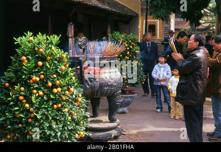 Vietnam: Tet (Capodanno vietnamita) celebranti a Tran Quoc Pagoda, ho Tay (Lago Ovest), Hanoi. Il tempio più antico di Hanoi, Chua Tran Quoc, si trova su una piccola isola appena ad ovest della strada sopraelevata di ho Tay. Le origini precise della pagoda sono sconosciute, ma secondo la leggenda fu originariamente fondata dalle rive del Fiume Rosso durante il regno di Re Ly Nam De (544-548) in un breve interregno durante il millennio dell’occupazione cinese. La più grande festa nazionale del Vietnam è Tet – più propriamente, Tet Nguyen Dan, “Festival del primo giorno” – in coincidenza con il primo giorno del capodanno lunare. Foto Stock