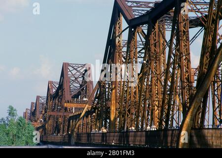 Vietnam: Il lungo ponte Bien, Hanoi. Il ponte Long Bien fu eretto dai colonialisti francesi tra il 1899 e il 1902 e nominato ponte Paul Doumer in onore dell'allora governatore dell'Indochina francese (1897-1902). È stato progettato e costruito da Dayde e Pille di Parigi (le placche originali sono ancora in atto) ed è lungo 1.682 metri (5.518 piedi), composto da 18 campate, con un'ulteriore estensione centrale allungata di 106 metri (347 piedi). Trasporta l'unica linea ferroviaria tra Hanoi e Haiphong, così come due collegamenti ferroviari vitali con la Cina. Foto Stock