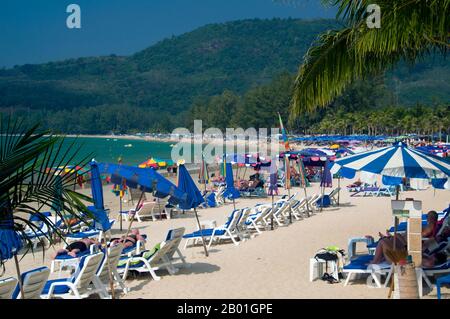 Thailandia: Ombrelloni colorati, Hat Kamala (Kamala Beach), Phuket. Phuket, a 810 kmq, l'isola piu' grande della Tailandia, si trova nel Mare delle Andamane, appena al largo della costa della Provincia di Phang-nga. Unito alla terraferma da un'ampia strada rialzata, si e' sviluppato nel piu' lussuoso e squisito resort sulla spiaggia della Tailandia. Nei secoli passati Phuket era un importante centro commerciale sulla costa orientale della baia del Bengala, che gestiva le spedizioni e si occupava di marinai provenienti dai mondi arabi e malesi, dall'India, dalla Birmania (Myanmar), dalla Cina e, naturalmente, Siam. Nel XVI secolo l'isola era ben nota anche agli europei. Foto Stock