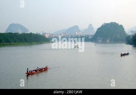 Cina: Dragon boat sul fiume li, Guilin, provincia del Guangxi. Il Guilin's Dragon Boat Festival si svolge il quinto giorno del quinto mese (maggio) del calendario lunare cinese ogni 3 anni. Il festival si tenne originariamente in memoria del grande poeta cinese, Quyuan. Il nome Guilin significa «Cassia Woods» e prende il nome dalle fioriture di osmanto (cassia) che fioriscono durante tutto il periodo autunnale. Guilin è la scena dei paesaggi più famosi della Cina, ispirando migliaia di dipinti nel corso di molti secoli. Foto Stock