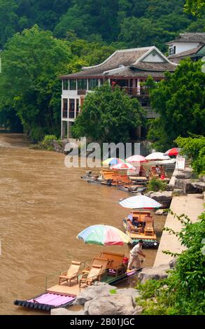 Cina: Zattere di bambù attendono i clienti a Yangshuo, vicino a Guilin, provincia del Guangxi. Yangshuo è famosa per i suoi paesaggi suggestivi. Si trova sulla riva occidentale del fiume li (Lijiang) ed è a soli 60 km a valle di Guilin. Negli ultimi anni è diventata una destinazione popolare tra i turisti pur mantenendo la sua atmosfera di piccola città fluviale. Guilin è la scena dei paesaggi più famosi della Cina, ispirando migliaia di dipinti nel corso di molti secoli. Le "montagne e fiumi più belli sotto il cielo" sono così stimolanti che poeti, artisti e turisti hanno reso questa attrazione naturale numero uno della Cina. Foto Stock