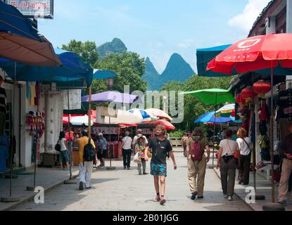 Cina: Turisti a Xi Jie ('Foreigner Street'), Yangshuo, vicino Guilin, provincia del Guangxi. Yangshuo è giustamente famosa per i suoi paesaggi suggestivi. Si trova sulla riva occidentale del fiume li (Lijiang) ed è a soli 60 chilometri a valle di Guilin. Negli ultimi anni è diventata una destinazione popolare tra i turisti pur mantenendo la sua atmosfera di piccola città fluviale. Guilin è la scena dei paesaggi più famosi della Cina, ispirando migliaia di dipinti nel corso di molti secoli. Sono stati spesso chiamati “le montagne più belle e i fiumi sotto il cielo”. Foto Stock