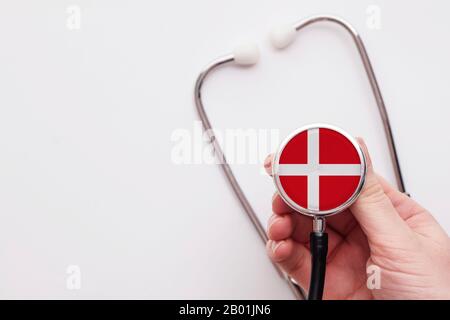 Concetto di assistenza sanitaria in Danimarca. Medico che detiene uno stetoscopio medico. Foto Stock