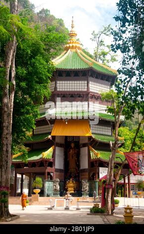 Thailandia: Pagoda Housing a Guan Yin image, Wat Tham Seua, Krabi Town, Krabi Province, Thailandia meridionale. Wat Tham Seua, il "Tempio della Grotta della Tigre" è costruito in una grotta posta su una scogliera calcarea. Circondato da residenze monache individuali, questo è uno dei templi forestali più noti della Thailandia meridionale. Il viharn principale o sala di assemblaggio si estende in una lunga grotta calcarea poco profonda che mostra vari tristi ricordi della mortalità come controbilanciamento ai desideri mondani. Sul retro della grotta una rampa di scale di marmo conduce alla "grotta della tigre" stessa. Foto Stock