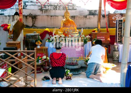 Thailandia: Devoti davanti al chedi a Wat Duang di, Chiang mai. Il Wat Duang di o 'Monastero della buona fortuna' risale al XIX secolo ed è famoso per i suoi frontoni scolpiti e altre decorazioni in stucco. Re Mengrai fondò la città di Chiang mai (che significa "nuova città") nel 1296, e succedette a Chiang Rai come capitale del regno Lanna. Chiang mai, talvolta scritta come "Chiengmai" o "Chiangmai", è la città più grande e culturalmente significativa del nord della Thailandia. Foto Stock