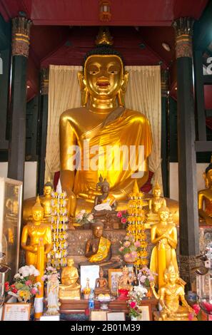 Thailandia: Buddha nel più piccolo e antico viharn a Wat Buppharam, Chiang mai, Thailandia settentrionale. Wat Buppharam fu originariamente costruito nel 1497. Nel 1797 Chao (principe) Kawila, un discendente della dinastia Tipchak, iniziò la sua cirambulazione rituale di Chiang mai da questo punto. Questo rituale fu richiesto per rioccupare formalmente la città dopo due secoli di dominazione birmana. Chiang mai è spesso chiamata la «Rosa del Nord» della Thailandia ed è la seconda città del paese e una popolare destinazione turistica grazie soprattutto al suo paesaggio montuoso, alle variopinte tribù di colline etniche e ai loro oggetti di artigianato. Foto Stock