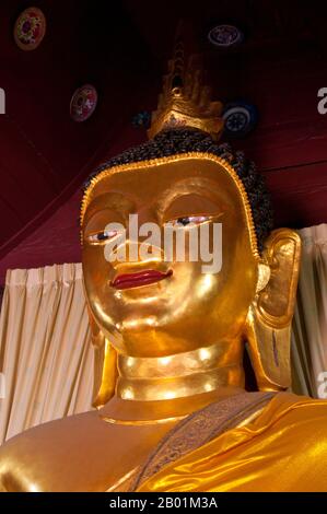 Thailandia: Buddha nel più piccolo e antico viharn a Wat Buppharam, Chiang mai, Thailandia settentrionale. Wat Buppharam fu originariamente costruito nel 1497. Nel 1797 Chao (principe) Kawila, un discendente della dinastia Tipchak, iniziò la sua cirambulazione rituale di Chiang mai da questo punto. Questo rituale fu richiesto per rioccupare formalmente la città dopo due secoli di dominazione birmana. Chiang mai è spesso chiamata la «Rosa del Nord» della Thailandia ed è la seconda città del paese e una popolare destinazione turistica grazie soprattutto al suo paesaggio montuoso, alle variopinte tribù di colline etniche e ai loro oggetti di artigianato. Foto Stock