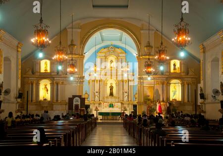 Filippine: Un servizio si svolge a St. William's Cathedral, Laoag, Ilocos Norte, Luzon Island. St La Cattedrale di Guglielmo, nota anche come Cattedrale di Laoag, fu originariamente costruita nel 1612 dai frati agostiniani per sostituire una cappella di legno. È noto per il suo design rinascimentale italiano e per il suo campanile che affonda nel terreno ad un ritmo di un pollice all'anno. Laoag (Ilocano per "luce o chiarezza"), è un antico e fiorente insediamento conosciuto dai commercianti cinesi e giapponesi quando il conquistador spagnolo Juan de Salcedo arrivò sulle rive settentrionali del fiume Padsan nel 1572. Foto Stock