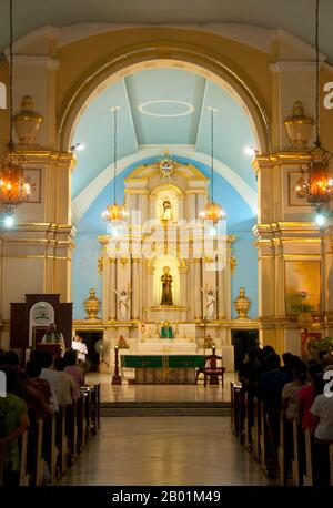 Filippine: Un servizio si svolge a St. William's Cathedral, Laoag, Ilocos Norte, Luzon Island. St La Cattedrale di Guglielmo, nota anche come Cattedrale di Laoag, fu originariamente costruita nel 1612 dai frati agostiniani per sostituire una cappella di legno. È noto per il suo design rinascimentale italiano e per il suo campanile che affonda nel terreno ad un ritmo di un pollice all'anno. Laoag (Ilocano per "luce o chiarezza"), è un antico e fiorente insediamento conosciuto dai commercianti cinesi e giapponesi quando il conquistador spagnolo Juan de Salcedo arrivò sulle rive settentrionali del fiume Padsan nel 1572. Foto Stock