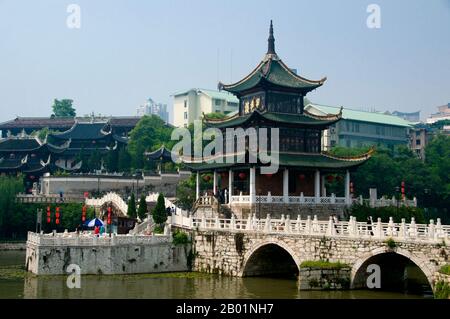 Cina: Jiaxiu Lou (prima torre di Scholar) sul fiume Nanming con la casa da tè Cuiwei Yuan sullo sfondo, Guiyang, provincia di Guizhou. Jiaxiu Lou (prima torre di Scholar) fu, insieme al ponte Fuyu, originariamente costruito nel 1598 (era Ming). Il ponte è utilizzato per raggiungere la torre a tre piani. La torre fu costruita per incoraggiare gli studenti e gli intellettuali nei loro studi verso gli esami imperiali Ming. Guiyang è la capitale della provincia cinese di Guizhou ed è situata ad est dell'altopiano dello Yunnan-Guizhou, e sulla riva settentrionale del fiume Nanming, un ramo del fiume Wu. Foto Stock