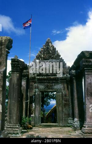 Cambogia: La bandiera cambogiana vola in cima a un gopura (ingresso) a Preah Vihear, un antico tempio Khmer al confine con la Thailandia. Adagiato su una scogliera al limitare dei Monti Dongrak, affacciato sulla Cambogia, Preah Vihear (conosciuta ai thailandesi come Khao Phra Viharn) è notevole sia per la sua eccezionale architettura Khmer che per la sua posizione mozzafiato. A lungo rivendicato sia dalla Thailandia che dalla Cambogia, il complesso del tempio fu infine assegnato a quest'ultimo dalla Corte Mondiale nel 1963, anche se la questione della proprietà irradia ancora molti thailandesi. Preah Vihear ha impiegato circa 200 anni per costruire. Foto Stock