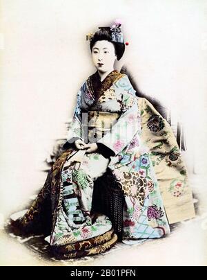 Giappone: Ritratto colorato a mano di una maiko in abito cerimoniale completo. Foto dallo studio Narui Raisuke (1858-1902), Kyoto, c. 1880. Maiko (舞妓?) è una parola giapponese che indica una ragazza danzante e significa un apprendista geisha. Di solito tra i 17 e i 20 anni, il loro lavoro consiste nell'eseguire canzoni, balli e suonare lo shamisen o altri strumenti tradizionali giapponesi per i visitatori durante banchetti e feste, noti come ozashiki. Si diplomano allo status di geisha dopo un periodo di formazione, e l'apprendistato può durare da pochi mesi a due anni. Sono noti come hangyoku (半玉) a Tokyo. Foto Stock