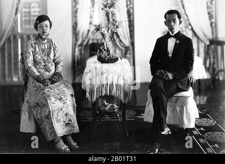 Malesia/Singapore: Una sposa e uno sposo Peranakan nella loro camera nuziale, Penang, c. 1920. Peranakan Chinese e Baba-Nyonya sono termini usati per indicare i discendenti degli immigrati cinesi della fine del XV e XVI secolo nell'arcipelago malese-indonesiano di Nusantara durante l'era coloniale. I membri di questa comunità in Malesia si identificano come "Nyonya-Baba" o "Baba-Nyonya". Nyonya è il termine per le femmine e Baba per i maschi. Si applica in particolare alle popolazioni etniche cinesi degli insediamenti dello stretto britannico della Malesia e dell'isola di Giava controllata dagli olandesi e di altre località. Foto Stock