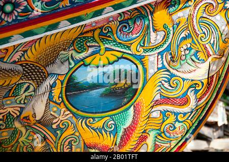 Thailandia: Korlae Fishing boats, Saiburi, Thailandia meridionale. Lungo la costa orientale della Thailandia peninsulare, da Ko Samui verso sud, barche colorate e dipinte da pescatori musulmani sono state costruite e decorate per centinaia di anni. I migliori esempi di questa industria ora in declino hanno origine nei cantieri navali del distretto di Saiburi, nella provincia di Pattani. Originariamente barche a vela, le corna sono ora alimentate da motori da pescatori locali. Tra i personaggi comunemente raffigurati sui disegni superbamente dettagliati dello scafo ci sono il leone singha, l'uccello corna gagasura, il serpente marino payanak e il garuda B. Foto Stock