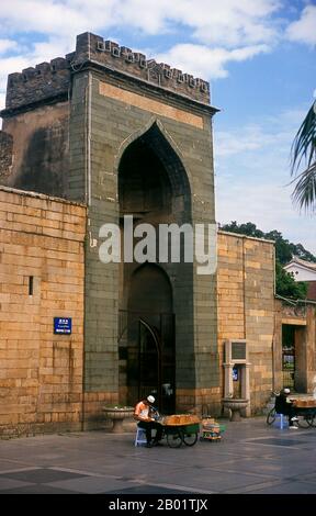 Cina: Venditore uiguro all'ingresso della moschea di Qingjing, Quanzhou, provincia del Fujian. La Moschea di Qingjing, nota anche come Moschea Ashab, fu inizialmente costruita nel 1009 durante la dinastia Song (960-1279). Era basata su una moschea a Damasco, in Siria, ed è la più antica moschea in stile arabo in Cina. La moschea, costruita e riparata da musulmani arabi, riflette il lungo scambio culturale tra la Cina e i paesi arabi. Mille anni fa Quanzhou era probabilmente il porto più importante del mondo, con una posizione lucrativa al centro del commercio marittimo della seta. Foto Stock