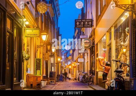 Leiden, Paesi Bassi - 16 gennaio 2020: Via dello shopping colorata con decorazioni natalizie nell'antico centro di Leiden, Paesi Bassi Foto Stock