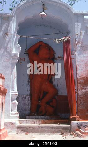 India: Una rappresentazione relativamente moderna di Hanuman, il dio delle scimmie, in un santuario nel vecchio villaggio di Khajuraho, Khajuraho, stato del Madhya Pradesh. Durante il X e l'XI secolo, i re Chandella dell'India centrale, le eredi di un potente clan Rajput che rivendicava la luna come loro antenato diretto, costruirono un totale di 85 templi per la gloria di Dio, la creazione e il pantheon indù. I Chandellas erano devoti indù. Eclissati dalla conquista moghul, dall'ascesa di dinastie rivali e dal passare del tempo, i templi languirono sotto il sole duro e le piogge monsoniche dell'India centrale. Foto Stock